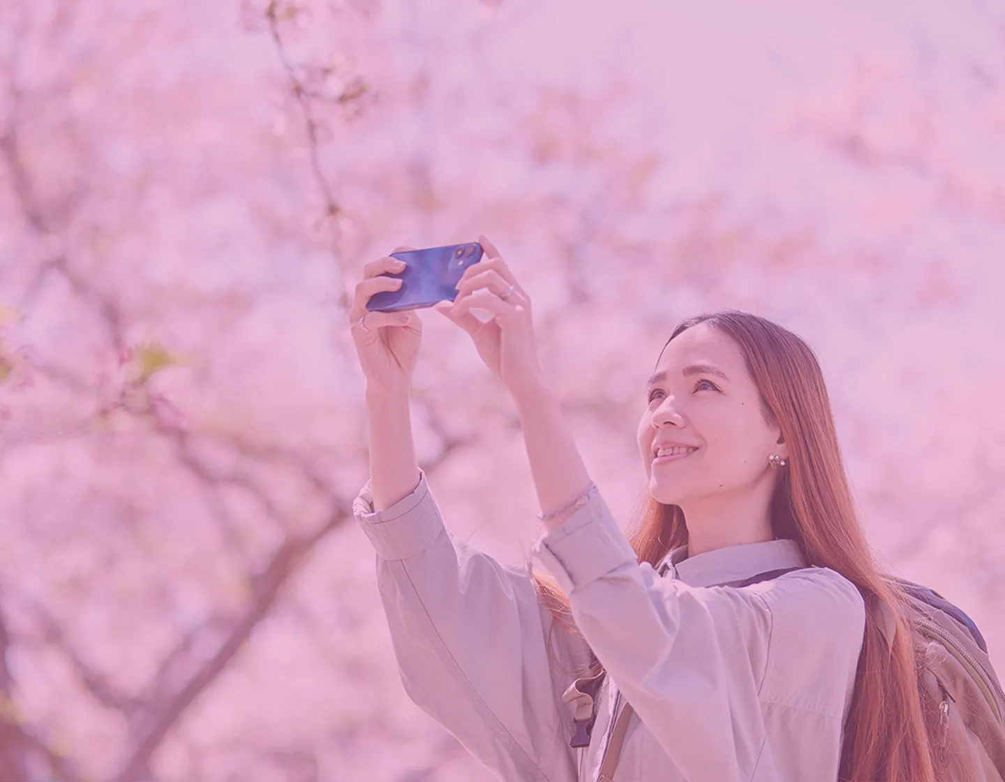 Traveler in Japan taking a photo with a phone using Sakura Mobile SIM or eSIM.