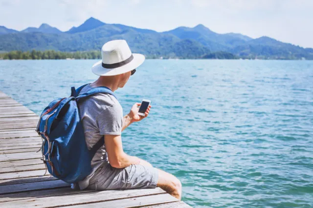 A man sitting on the pier, with a phone connected via local Japanese eSIM.