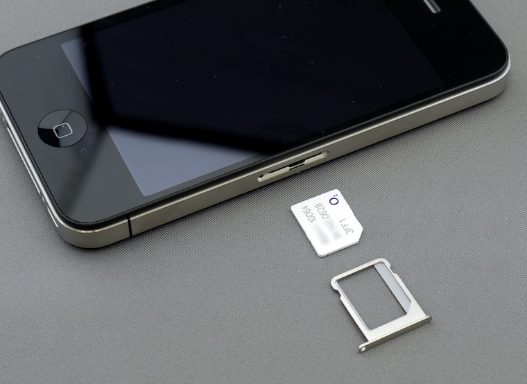 Close-up of a SIM card laying next to a smartphone, demonstrating the setup process for travelers using a physical SIM in Japan